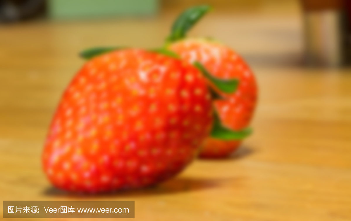 模糊新鲜草莓在木块上,彩色的水果在背景上